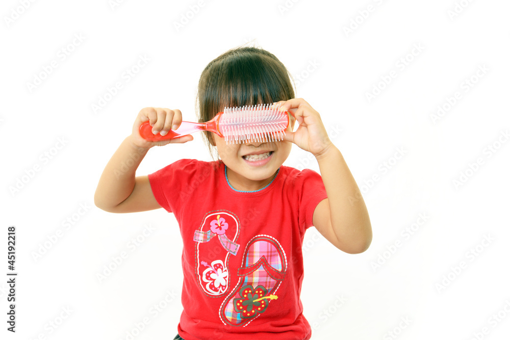 ヘアブラシで顔を隠す女の子 ヘアブラシで顔を隠す女の子