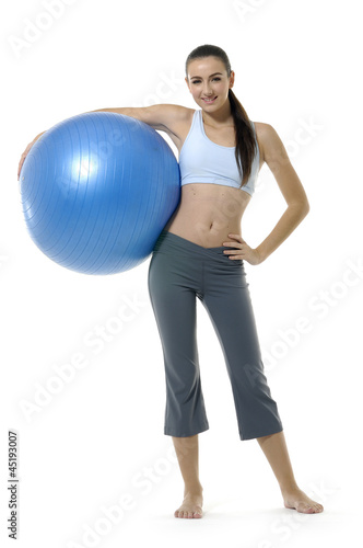 Young happy woman doing fitness exercises with ball
