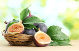 Ripe sweet figs with leaves in basket,