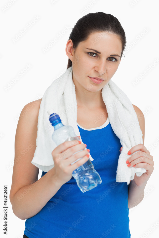 Brunette wearing sportswear with a towel and a bottle Brunette wearing sportswear with a towel and a bottle