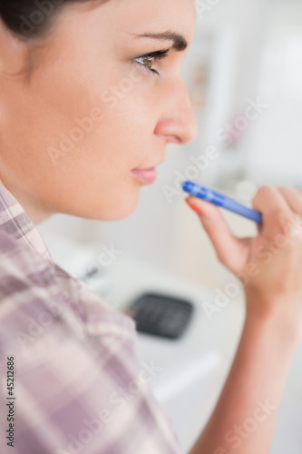 Thoughtful woman holding a pen