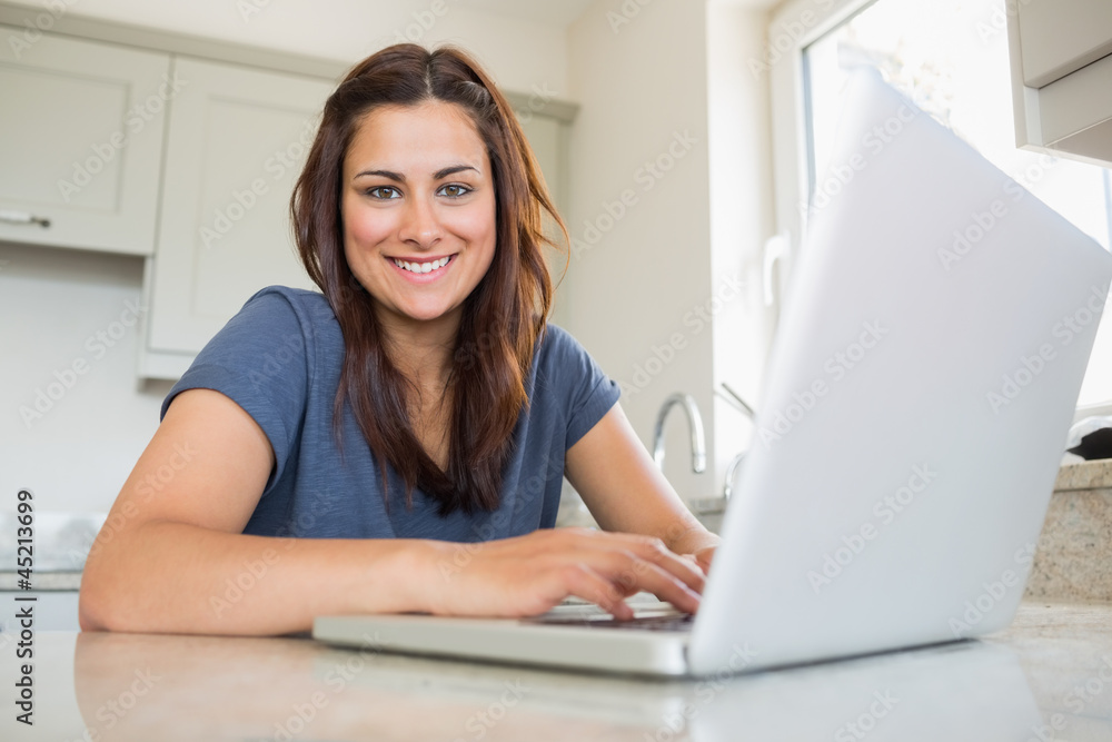 Woman smiling and using laptop Woman smiling and using laptop