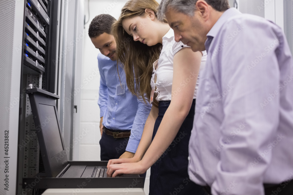 Three technicians looking at laptop