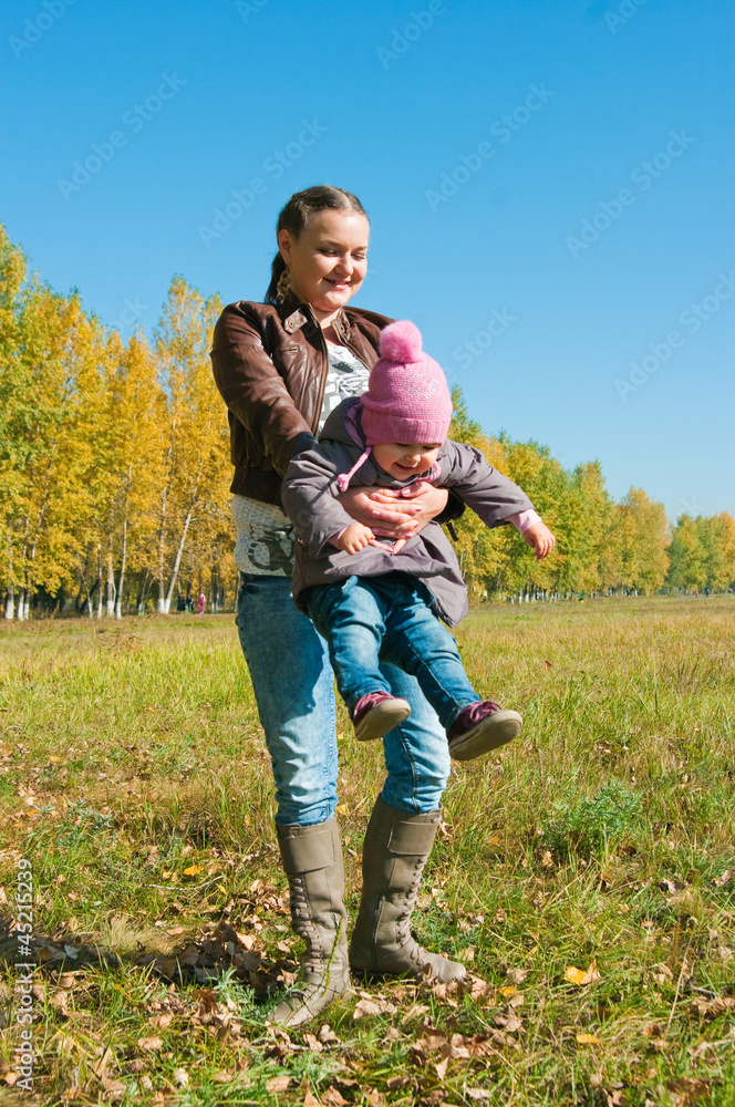Fototapeta premium The young woman with the daughter on walk