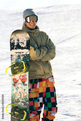 A snowbarder standing with his board photo