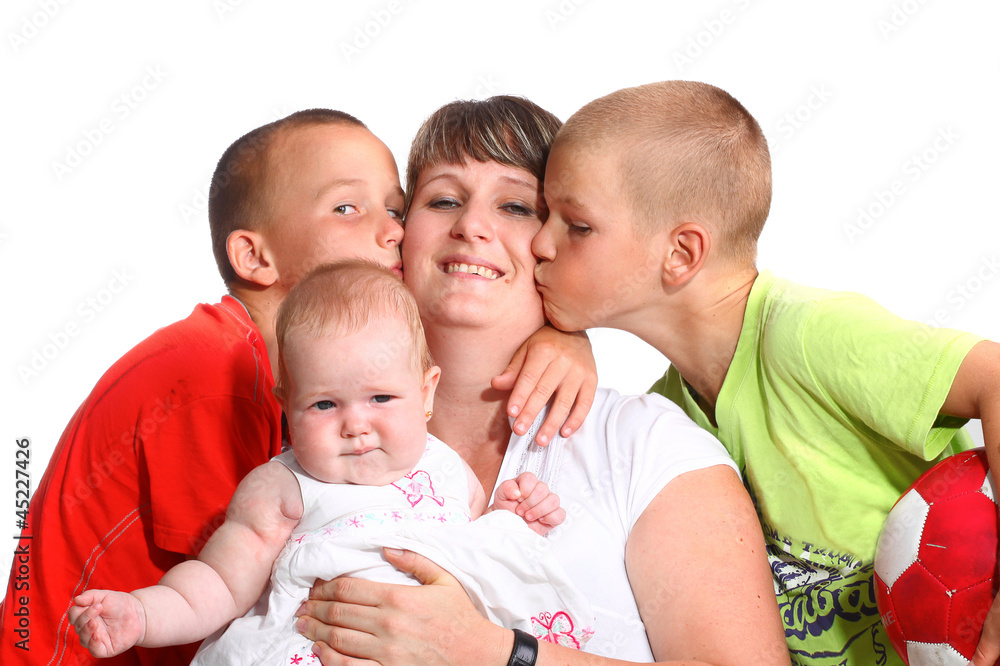 Happy woman with baby while being kissed by her sons Happy woman with baby while being kissed by her sons