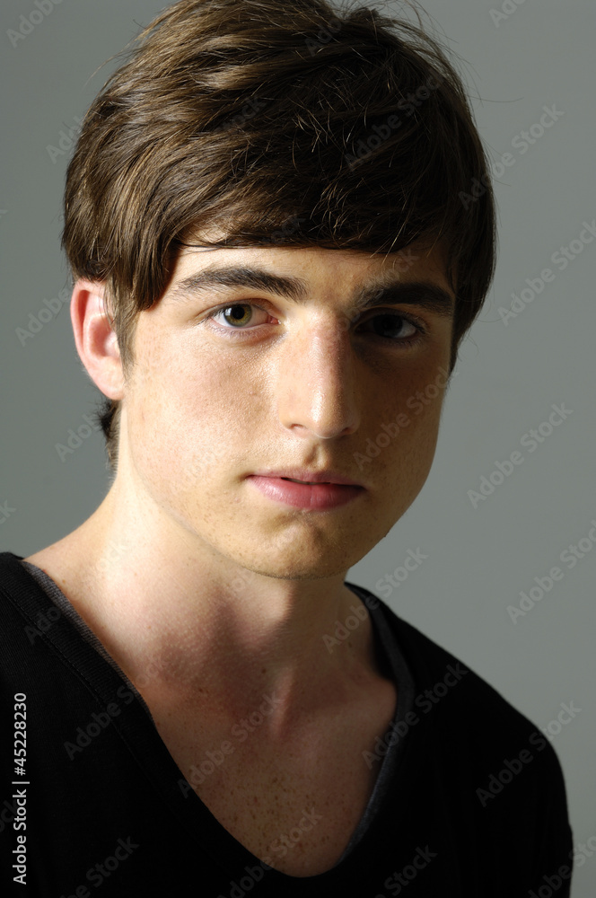 Close up handsome young man against gray Close up handsome young man against gray