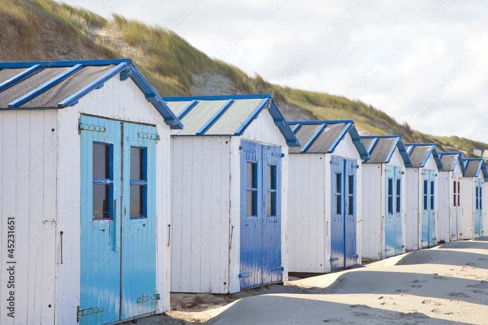 Naklejka premium Dutch little houses on beach in De Koog Texel, The Netherlands
