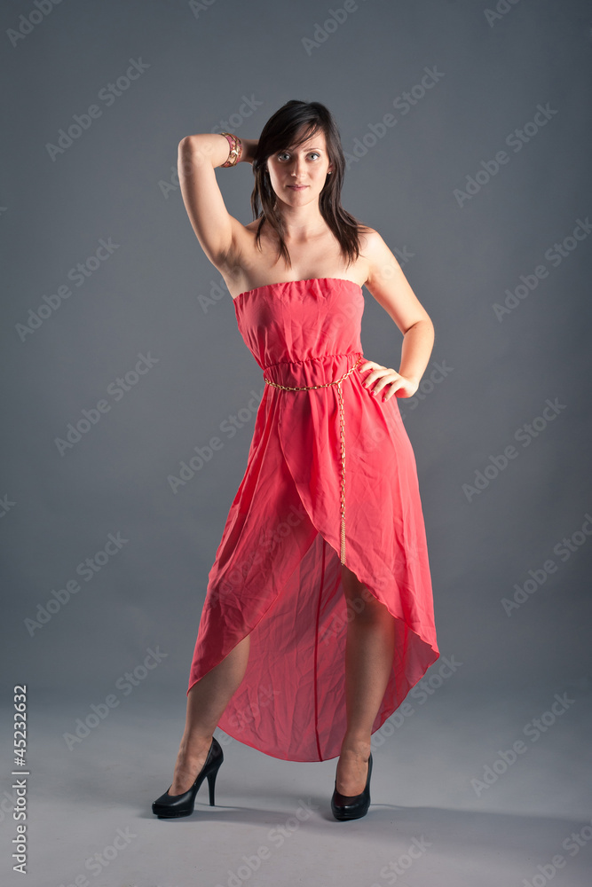 Beautiful woman with red dress against grey background. Beautiful woman with red dress against grey background.