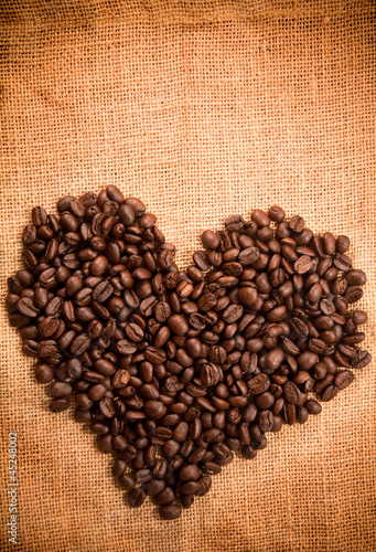 Heart sign by coffee bean on burlap texture
