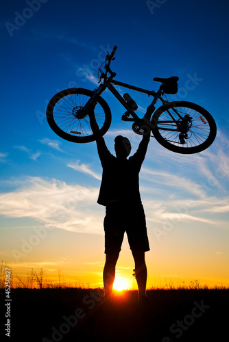 cyclist with a bike silhouette on a blue sky photo