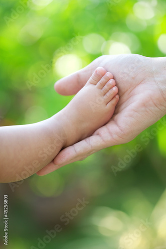 Baby foot is hold by father hand