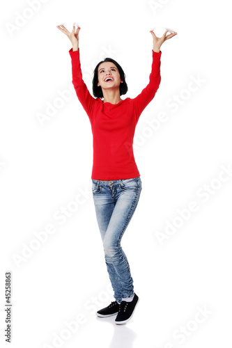 Woman  is holding something abstract above her head.