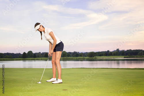 Girl golfer putting.