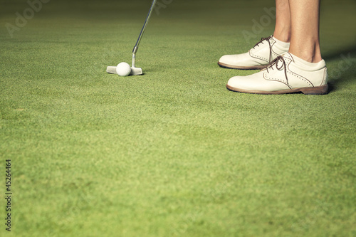 Close up of woman about to make a putt.