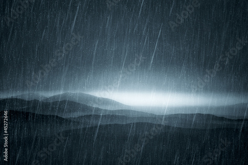 rain over hills at sunset
