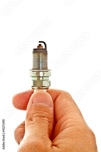 hand holding used spark plug on white background