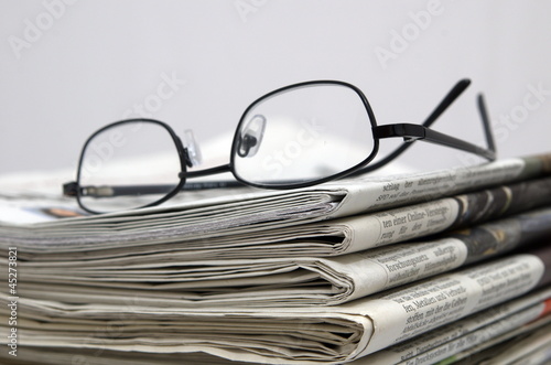 Zeitungen mit Brille