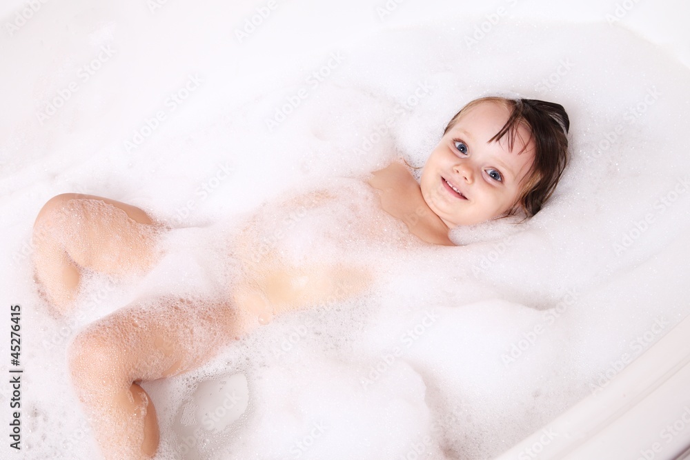 Little girl is relaxing in a bathtub with foam Little girl is relaxing in a bathtub with foam