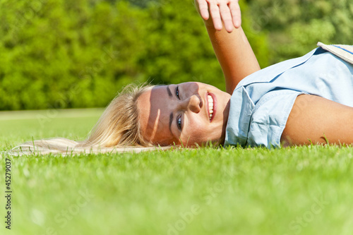 Beautiful young woman in park with big joyfull smile on green me