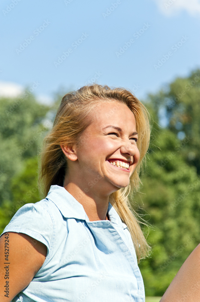 Beautiful young woman in park with big joyfulll smile on green m Beautiful young woman in park with big joyfulll smile on green m