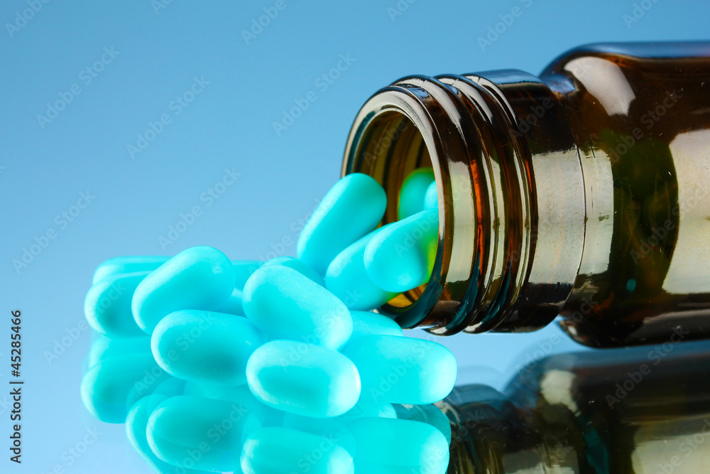 Obraz premium pills in bottle, on blue background