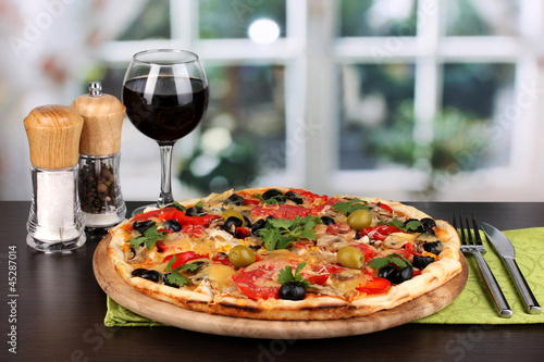 Delicious pizza with glass of red wine and spices