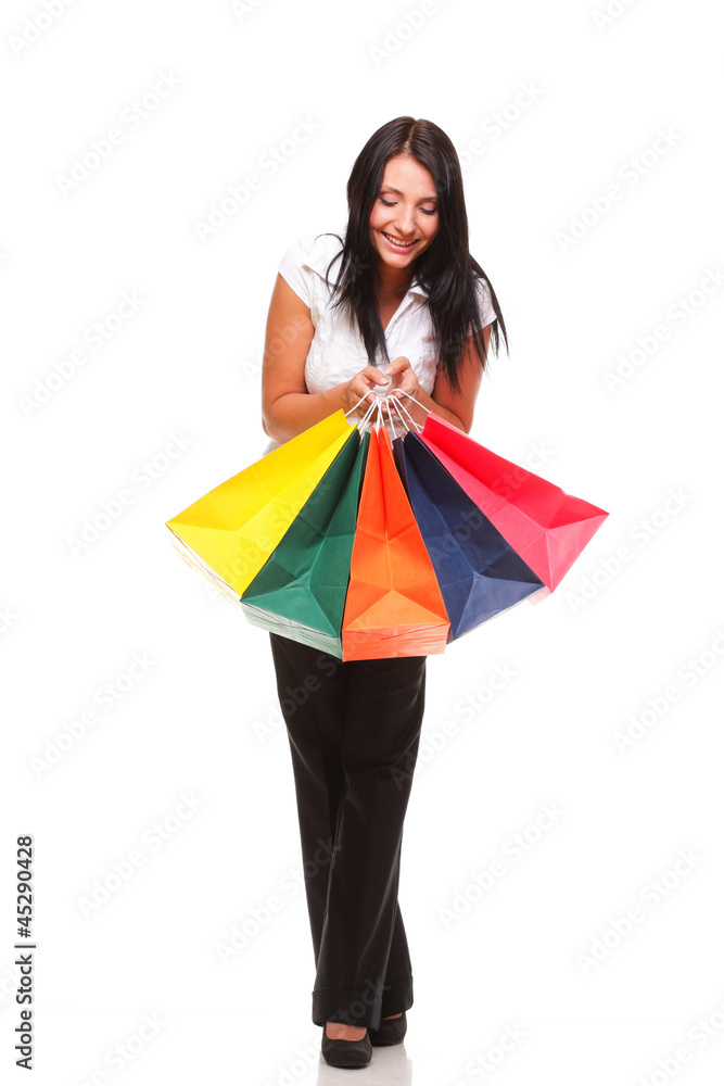 Portrait of young woman carrying shopping bags against white bac Portrait of young woman carrying shopping bags against white bac