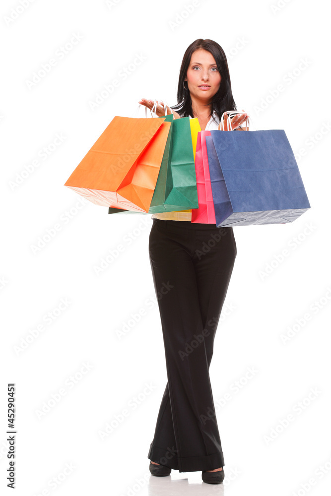 Portrait of young woman carrying shopping bags against white bac