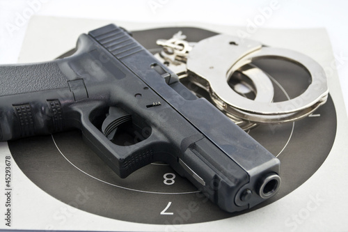 9-mm handgun automatic and police handcuff on white background