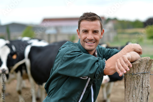 Foto Herdsman standing in front of cattle in farm