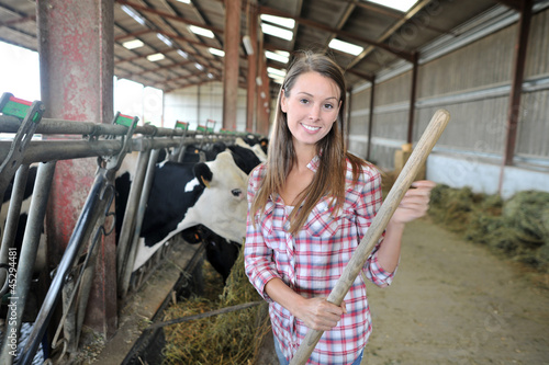 Smiling breeder woman giving food to cows photo