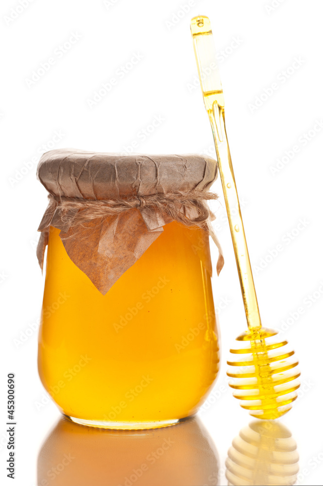 Jar of honey with a spoon on a white background Jar of honey with a spoon on a white background