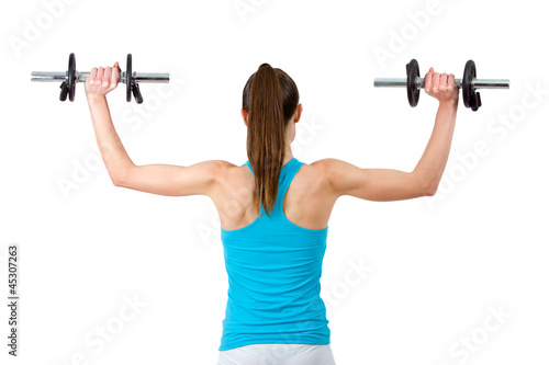 Rear view of woman lifting weights.