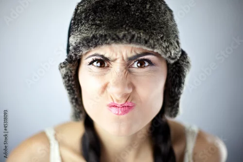 Fototapeta samoprzylepna Piękna kobieta w czarnej czapce ze zmarszczonym nosem