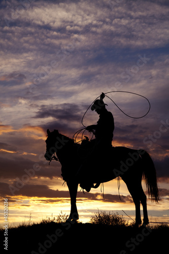 Cowboy on horse swinging rope