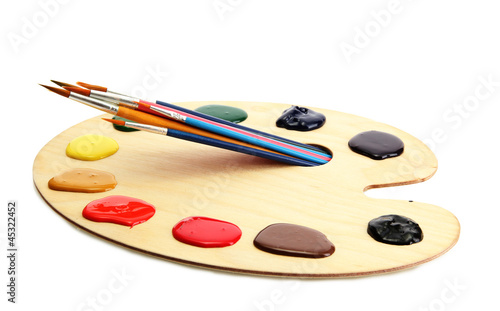 wooden art palette with paint and brushes.isolated on white