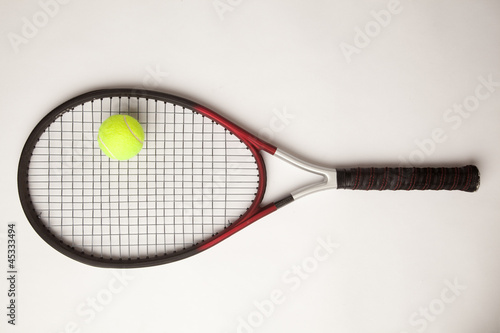 Tennisschläger mit Ball auf weißem Hintergrund photo