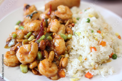 Plate of kung pao shrimp with rice and egg roll
