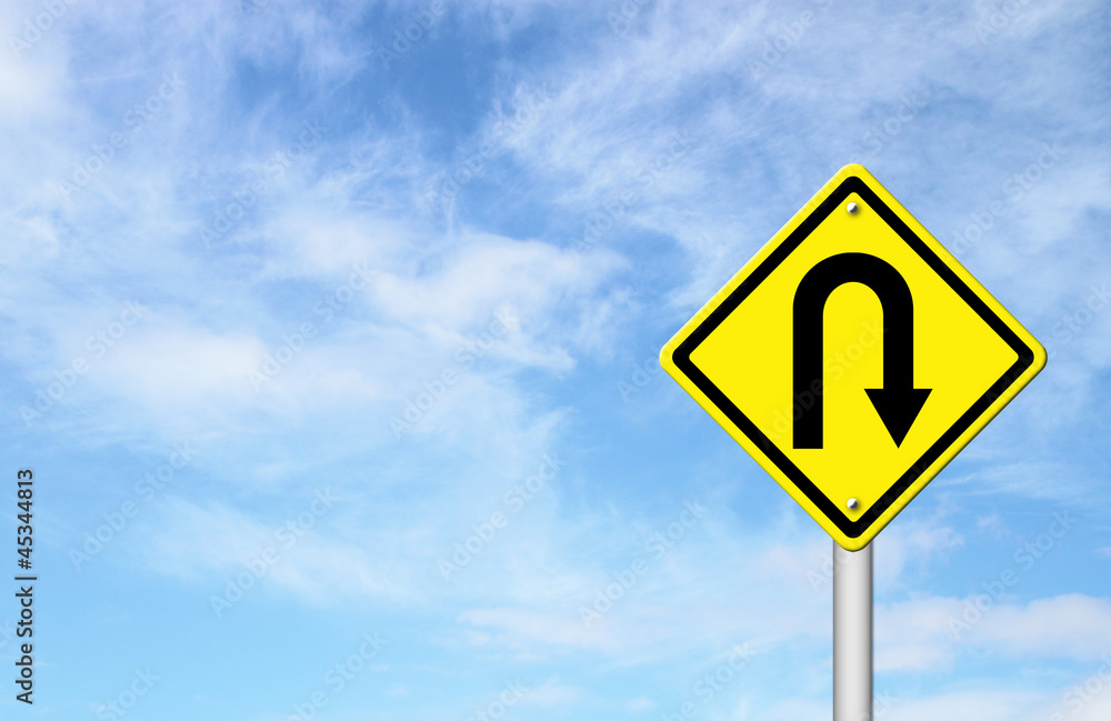 Yellow warning sign u-turn roadsign with blue sky background Yellow warning sign u-turn roadsign with blue sky background