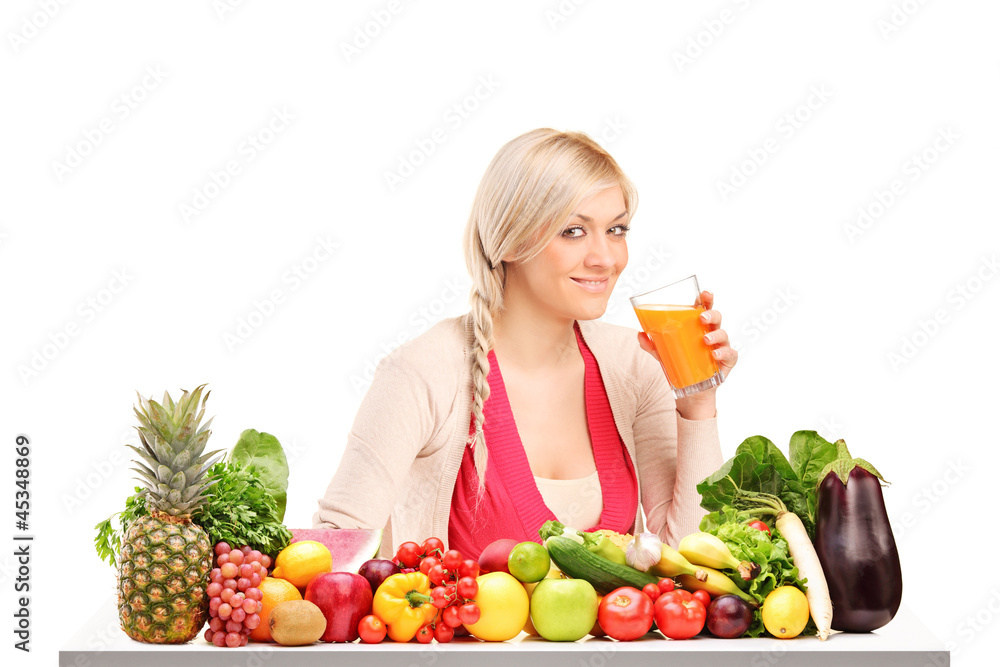 Beautiful woman drinking orange juice, on a table full of food Beautiful woman drinking orange juice, on a table full of food