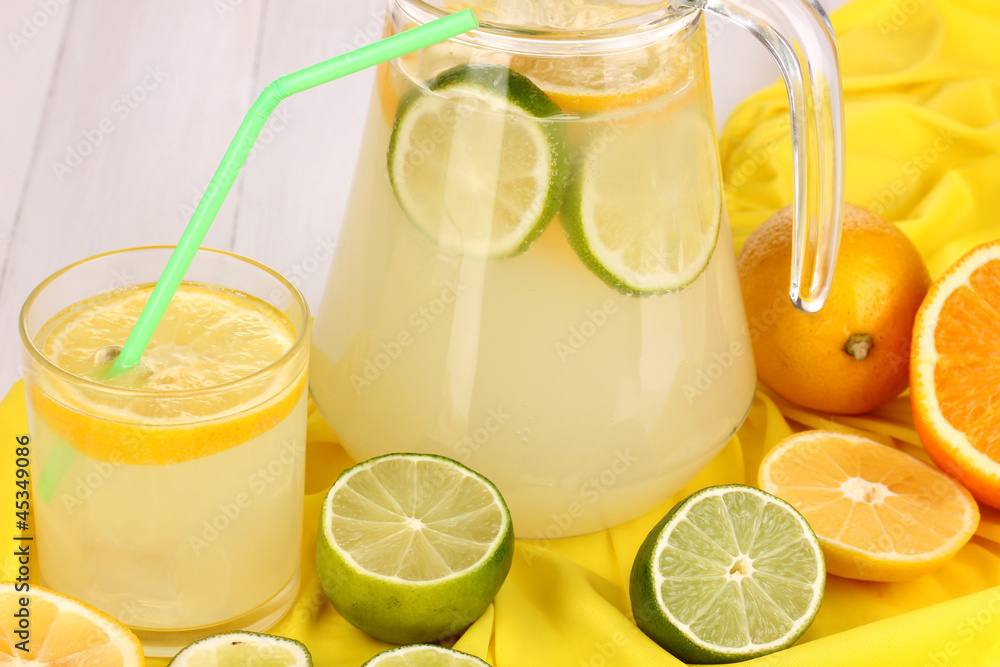 Citrus lemonade in glass and pitcher of citrus around Citrus lemonade in glass and pitcher of citrus around