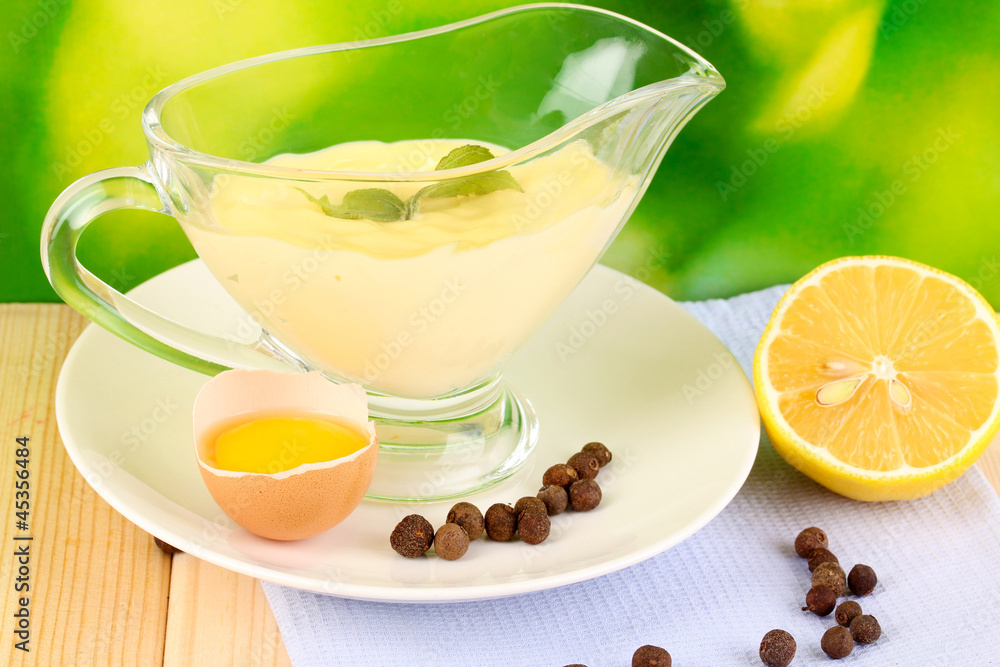 Mayonnaise in bowl on wooden table on nature background Mayonnaise in bowl on wooden table on nature background