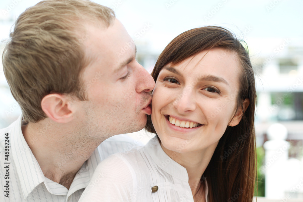 Portrait of young man kissing his girlfriend Portrait of young man kissing his girlfriend