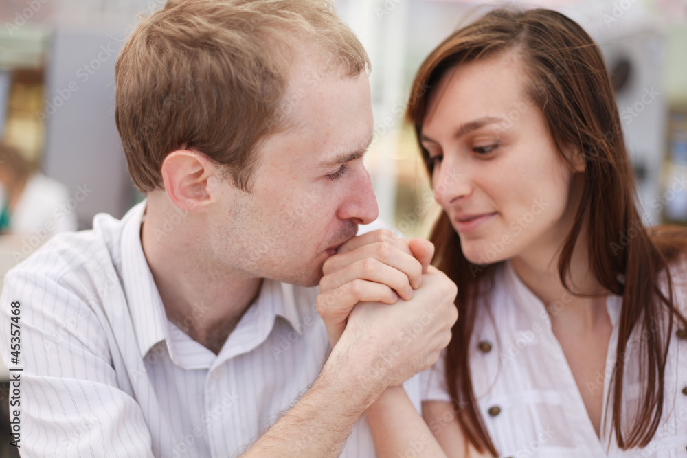 Young man kissing hand of his girlfriend on date Young man kissing hand of his girlfriend on date