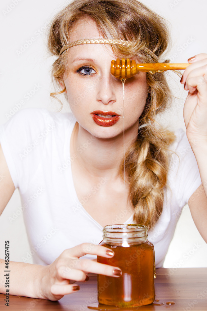 frau mit honiglöffel vor auge lässt honig in glas laufen – Stock-Foto |  Adobe Stock