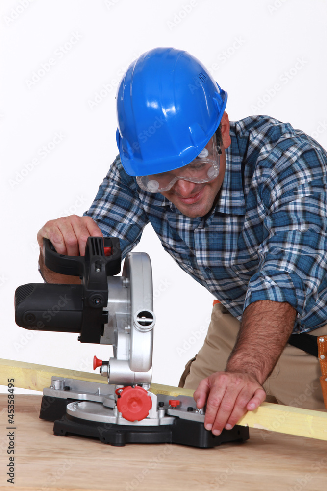 Carpenter using saw mounted to work surface Carpenter using saw mounted to work surface