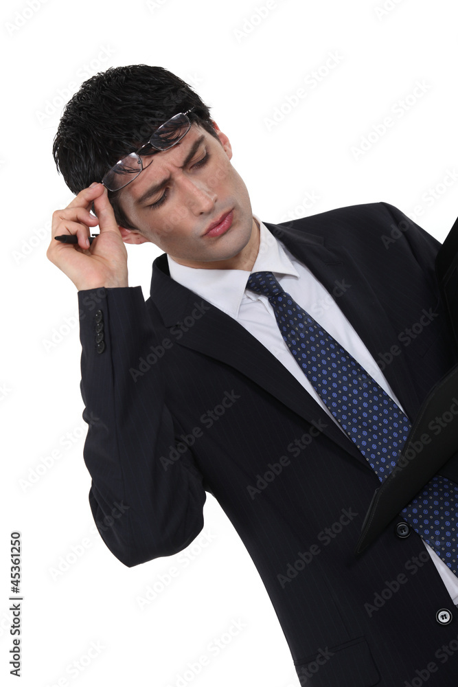 Confused businessman looking at paperwork Confused businessman looking at paperwork