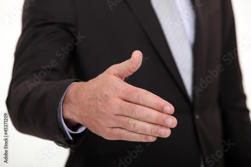 businessman stretching out hand to shake hands