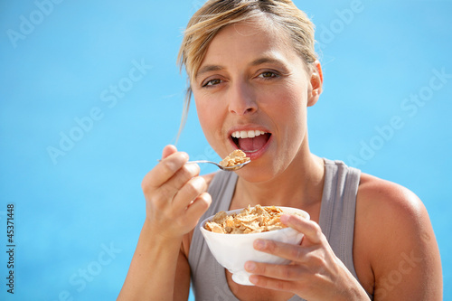 Healthy woman eating bowl of cereals
